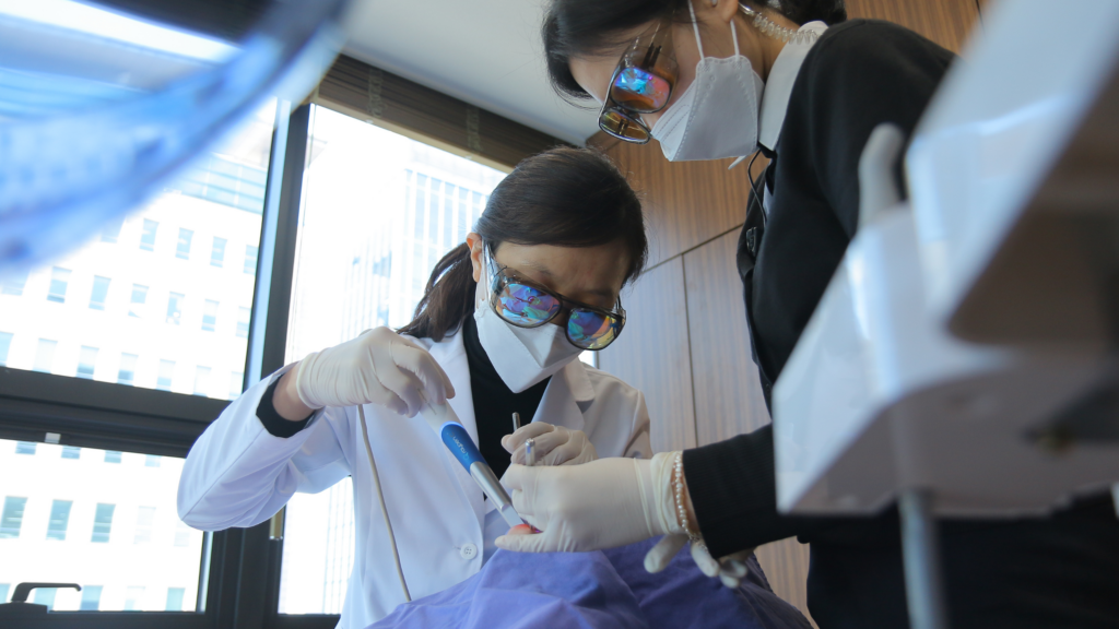 MINISH dentist performing a minimally invasive veneer procedure on a patient.