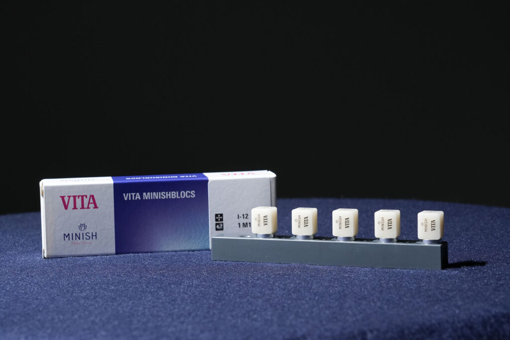 A box of VITA MINISHBLOCS next to five individual ceramic blocks used for milling precise MINISH dental restorations.
